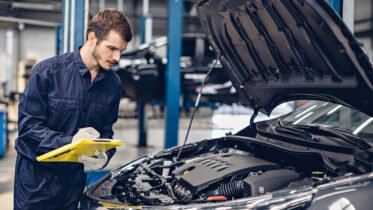 Auto Car Repair Service Center Mechanic Examining Car Engine